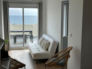 a living room with a couch and a view of the ocean at Magnolia Mar Apartamentos in Lagos