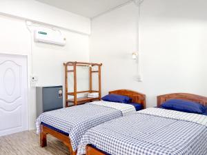 a room with two beds in a room at Jira Hotel in Lampang