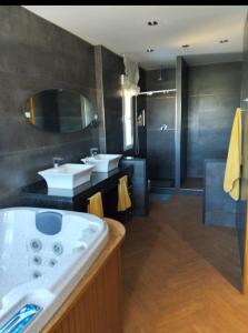 Un baño con dos lavabos y una bañera grande. en El Hogar de Pepe, en El Casar de Escalona