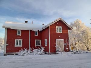 a red house with snow on the ground at Pyrrön pirtti, koko talo in Oulainen