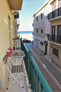 a balcony with a table and a view of the beach at Casa Carvalho Laranjo in Nazaré