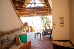 a living room with a large window and a chair at Pazuri kendwa Beach Hotel in Nungwi +41 photos