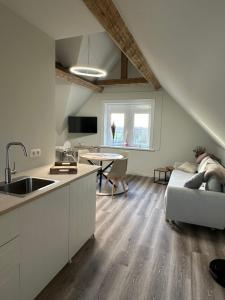 a kitchen and living room with a couch and a table at Gare de Pecq in Pecq