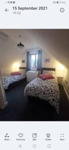 ein Schlafzimmer mit zwei Betten und einem Fenster in der Unterkunft Cottage with 360 views in Gilwern