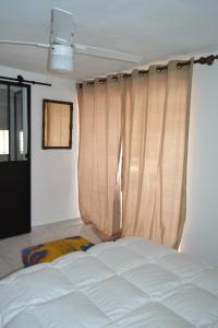 a bedroom with a white bed and curtains at Finca Diego García - studio vue mer in Vélez-Málaga +25 photos
