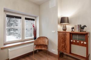 Una silla sentada en una habitación con ventana. en AirHome - Royal Family, en Tallin