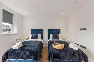 1 dormitorio con 2 camas y cesta de mimbre en Ground Floor Apartment Disabled Access Parking, en Leatherhead