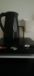 una taza negra sentada sobre una mesa en Giulietta Central Loft, en San Remo