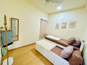 a room with two beds and a mirror at La Dimora Gamuda Cove Splash Mania in Pulau Kempas