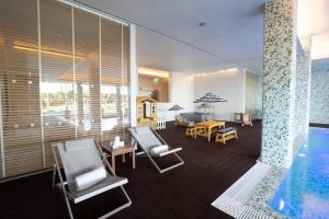 a room with a pool and chairs and a table at NAU Sao Rafael Suites - All Inclusive in Albufeira