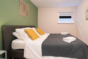 een slaapkamer met een bed met gele en witte kussens bij Alkmaar City Apartments in Alkmaar