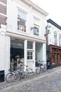 drie fietsen staan geparkeerd buiten een winkel bij Alkmaar City Apartments in Alkmaar