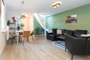 een woonkamer met een bank en een tafel bij Alkmaar City Apartments in Alkmaar