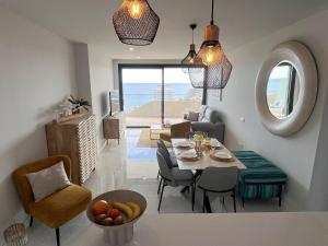 a dining room and living room with a table and chairs at Benidorm Beach apartment - Costa Blanca in Benidorm