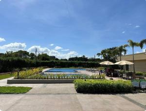 una piscina con tavoli e ombrelloni in un resort di Tulip Garden Apricot Bldg 1BR with pool and Gym a Biñan