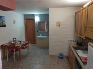 a kitchen with a table and a sink and a tv at taverna francesco in Orbassano