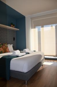 a bedroom with a bed with blue walls and a window at Alma Candida 21 in Valença