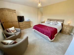 a bedroom with a bed and a chair and a television at The Pantry in Erwood