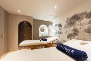 two beds in a room with a painting on the wall at Le Champlain in La Rochelle