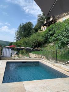 a swimming pool in front of a fence at Grande maison avec piscine sous les falaises de La Roque Gageac in Vézac