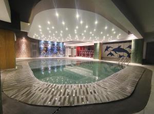 a swimming pool in a building with a ceiling with lights at Royal Pearl Suites in Cox's Bazar