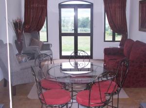 ein Wohnzimmer mit einem Glastisch und Stühlen in der Unterkunft River Crossing in Champagne Valley