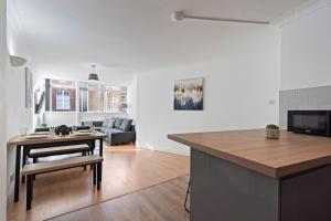 a kitchen and living room with a table and a couch at Leeds City Centre - Sleeps 5 - Free Parking in Leeds