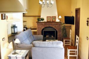 ein Wohnzimmer mit Sofa und Kamin in der Unterkunft Welcoming House in Alcaracejos with Shared Pool in Alcaracejos