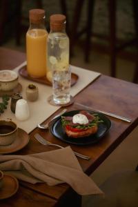 een tafel met een bord eten en een glas sinaasappelsap bij Plawa Laguna Bali in Canggu