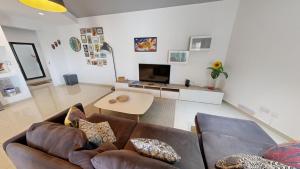 un salon avec un canapé et une table dans l'établissement Urban Family Retreat Modern Apartment With BBQ, à San Ġiljan