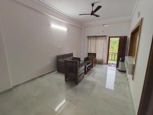 a living room with a couch and a ceiling fan at Cozy Corner Homestay in Madikeri +38 photos