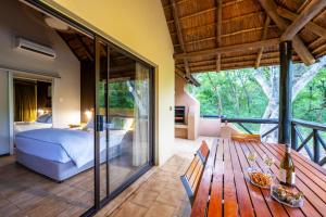a bedroom with a bed and a wooden deck at First Group Sanbonani Resort in Hazyview