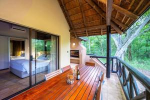 a wooden deck with a bed and a bedroom at First Group Sanbonani Resort in Hazyview