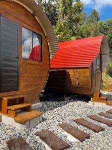 a circular house with a red roof on a gravel yard at Pousada Paiól Serrano in Agronômica +9 photos