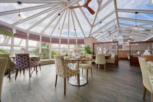 a dining room with a glass ceiling and tables and chairs at The Melbreak Hotel in Workington