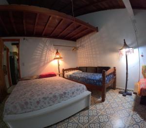 een slaapkamer met twee bedden en een lamp bij Sitio Flor do Coriscão Paraty in Paraty