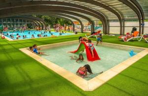 a group of people in a pool at a water park at ZEcamping chiens acceptés espace aquatique et bar in La Baule
