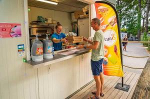 two men standing at a counter in a food truck at ZEcamping chiens acceptés espace aquatique et bar in La Baule +39 photos