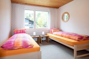 a bedroom with two beds and a window at Apartment Bischofberger D22 in Amden