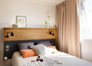 a bedroom with two beds and a window at ZEcamping familial dog friendly familial parc aquatique in Olonne-sur-Mer