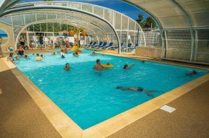 a group of people swimming in a swimming pool at ZEcamping animé piscine couverte club enfant animations dog friendly in La Faute-sur-Mer
