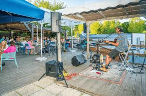 a man standing on a stage with a microphone at ZEcamping animé piscine couverte club enfant animations dog friendly in La Faute-sur-Mer +21 photos