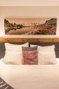 a bed with pillows and a painting on the wall at Appartement Ronacher in Eben im Pongau