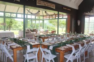 a long table with white chairs in a room at Barnside Guest House in Pietermaritzburg