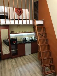 a loft bed with a kitchen and a staircase in a room at Center Lviv Avenue 23 in Lviv