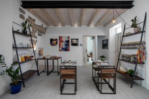 una stanza con tavoli, sedie e scaffali di Art and Nature Guest House a Olbia