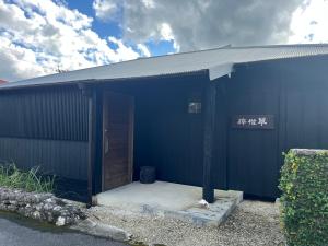 a blue building with a door in the side of it at 檸檬草ー奄美の自然の香る宿ー in Amami