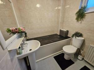 a bathroom with a tub and a toilet and a sink at Double Room Near Cardiff Bay Waterfront in Cardiff