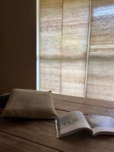 a book sitting on a table next to a window at 檸檬草ー奄美の自然の香る宿ー in Amami
