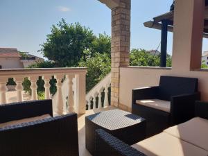 波弗加纳Apartmani "Bodulo"的阳台配有桌椅和栏杆。